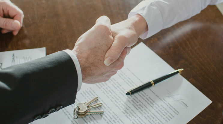 client and appraiser shaking hands pen and keys over contract lexington ky